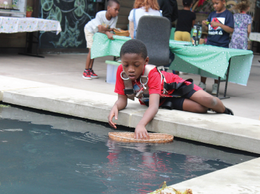 student placing basket into water